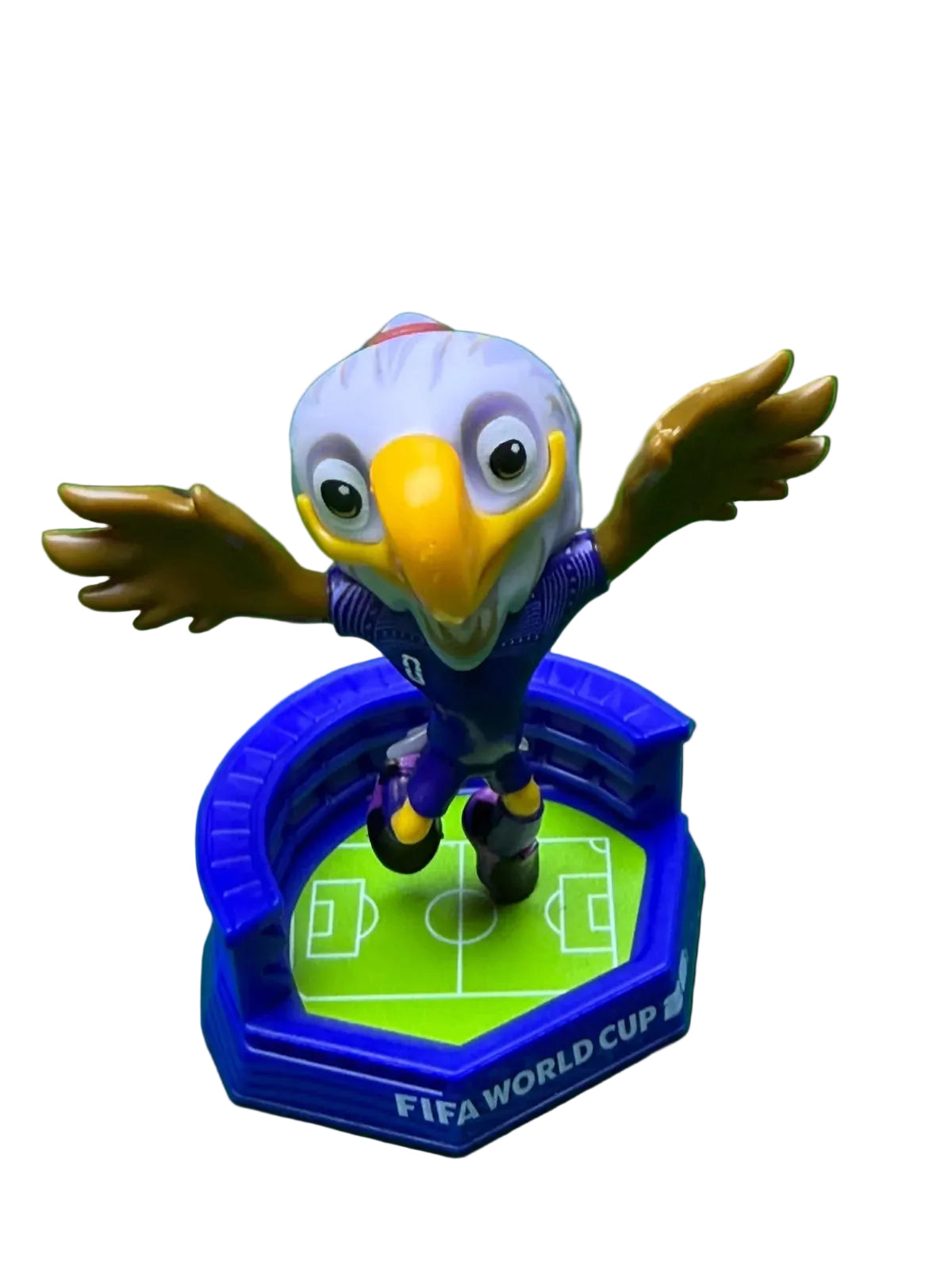 Toy figure of an eagle on a FIFA World Cup stand against a green background