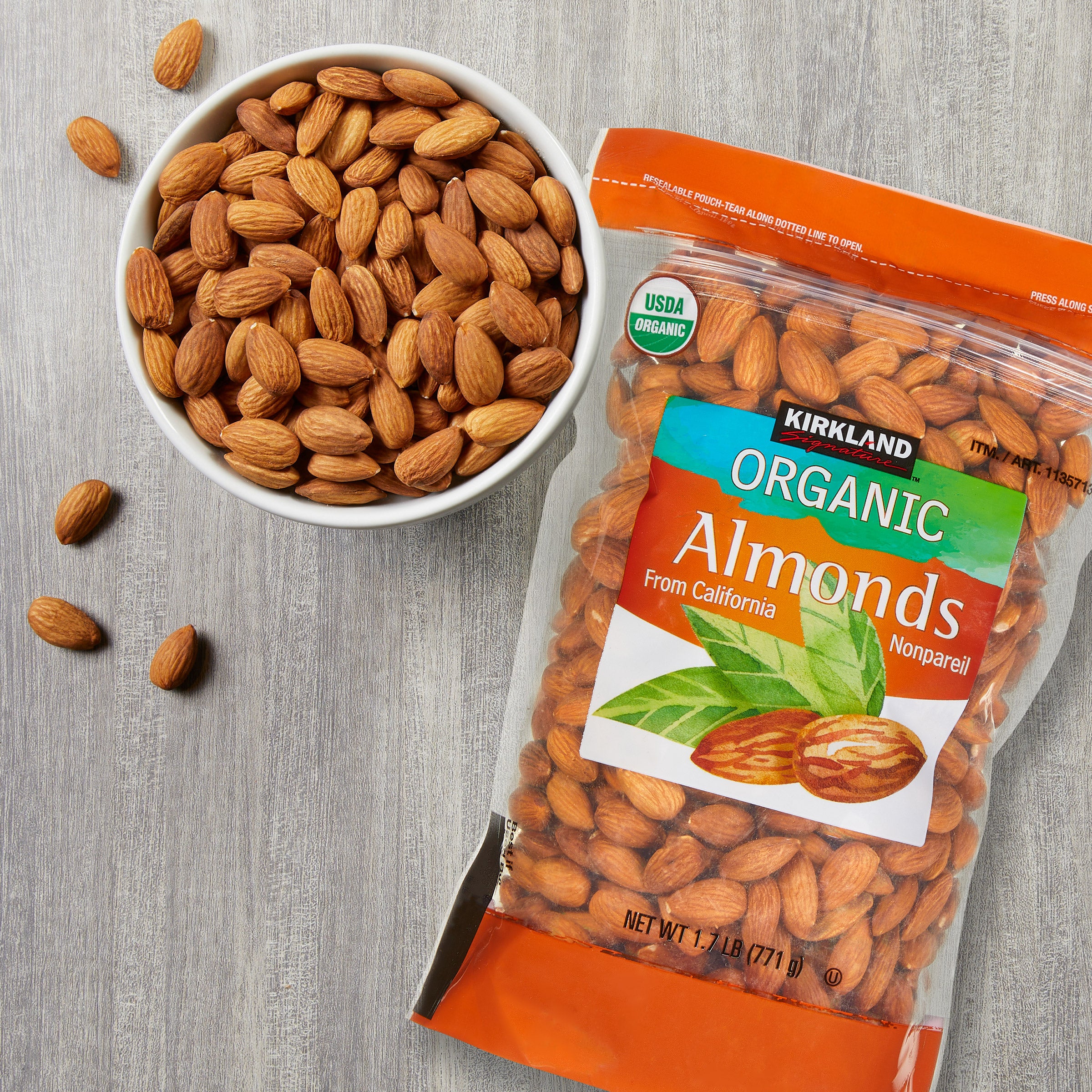 Kirkland Organic Almonds package and bowl of almonds on a gray surface