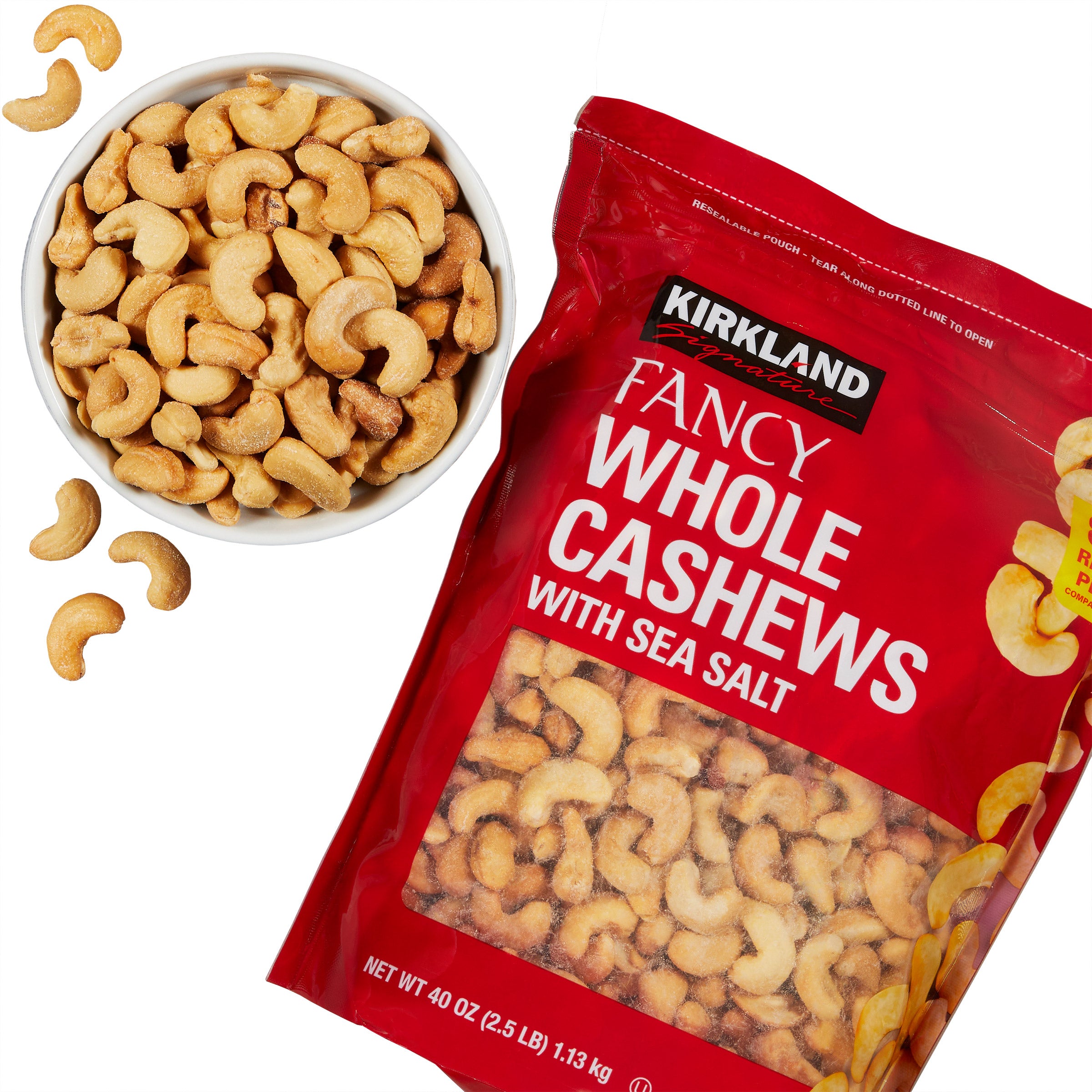 Kirkland Fancy Whole Cashews with Sea Salt packaging and bowl of cashews on a white background
