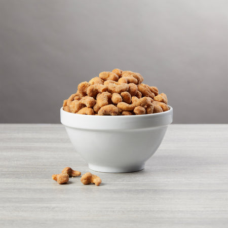 White bowl filled with dog treats on a gray surface with a gray background