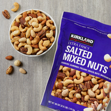 Kirkland Signature salted mixed nuts in a bowl and packaging on a gray surface