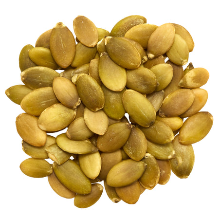 Pile of roasted pumpkin seeds on a white background