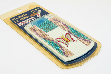 Beaded phone case with butterfly design in packaging on a white background