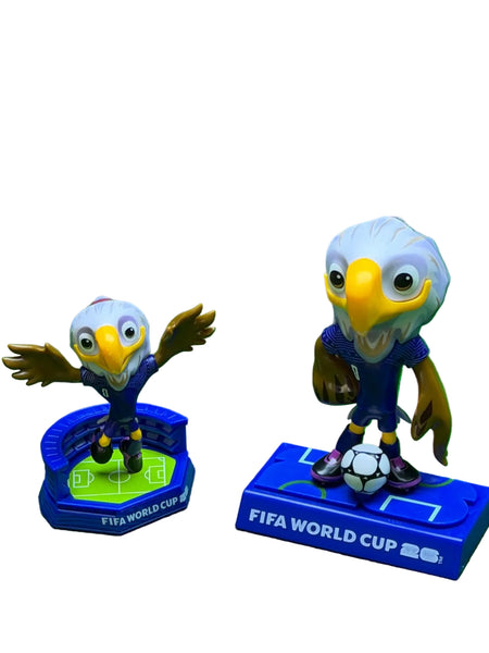 Two FIFA World Cup-themed figurines on a green background