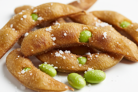 Close-up of crunchy roasted edamame beans showing golden texture and sea salt