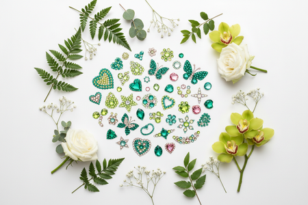 Green multi-color rhinestone phone stickers flat lay with natural green leaves and flowers