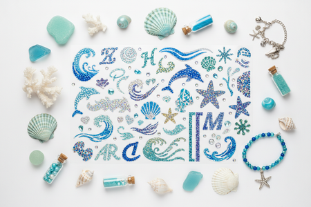 Blue multi-color rhinestone phone stickers flat lay with ocean-themed accessories