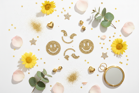 Golden smile rhinestone phone stickers flat lay with cheerful accessories and flowers